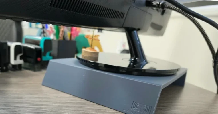 Support d'écran Manaora imprimé en 3D à Tahiti, logo gravé, placé sous un écran de bureau